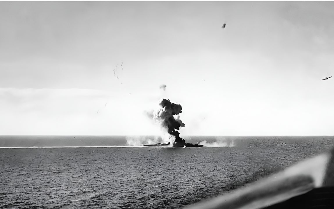 Bức ảnh này cho thấy tàu tuần dương hạng nặng Kumano bị Helldiver tấn công, thả bom 1.000 lb vào ngày 26 tháng 10 năm 1944, khi Lực lượng Tiến công Nghi binh Thứ Nhất rút lui qua biển Sibuyan. Trận đánh diễn ra tại eo biển Tablas, gần mũi nam đảo Mindoro. Nguồn tư liệu Nhật Bản cho biết ba quả bom (loại 500 lb – nếu đúng, thì chúng được thả bởi 12 chiếc F6F Hellcat tham gia đợt tấn công) đã đánh trúng con tàu, gây thiệt hại nghiêm trọng. Không chiếc TBM-1C ném ngư lôi nào ghi được cú đánh trúng bằng ngư lôi. Tàu tuần dương này vẫn có thể về cảng và sửa chữa, một lần nữa cho thấy sự khó khăn trong việc đánh chìm các tàu cỡ lớn chỉ bằng bom. (Real War Photos)