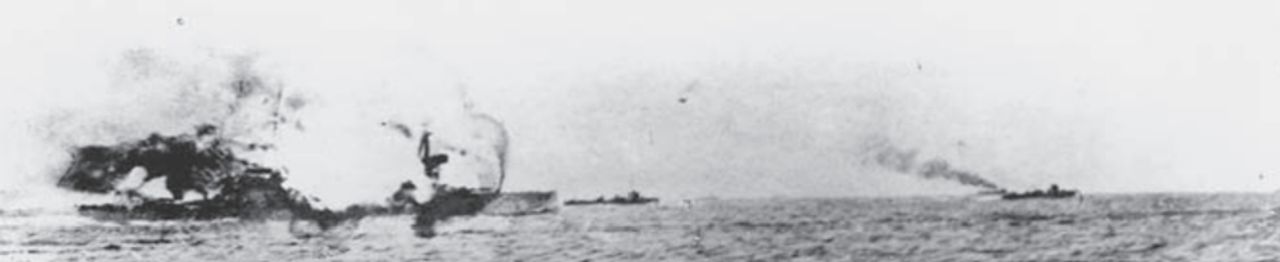 Bức ảnh đầy kịch tính này ghi lại khoảnh khắc vụ nổ trên tàu Invincible sau khi một quả đạn pháo của Đức bắn trúng tháp pháo giữa tàu (tháp pháo ‘Q’). Vụ nổ tạo ra ngọn lửa cao tới 400 feet, và khi khói tan sau khoảng 20 phút, chỉ còn lại phần mũi và đuôi tàu.