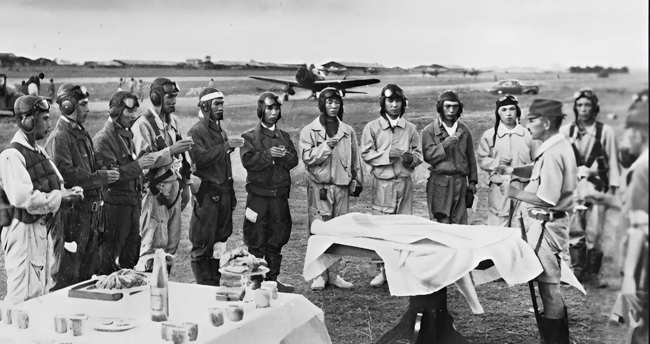 Phi công và thợ máy của Đơn vị Tấn công Đặc biệt Kyokko-Tai thuộc Lục quân Nhật nhận ly tiễn biệt trước khi lên đường thực hiện phi vụ kamikaze ở Philippines tháng 11 năm 1944. Đơn vị này sử dụng máy bay ném bom hạng nhẹ Type 99 (“Lily”). (via Edward M. Young)