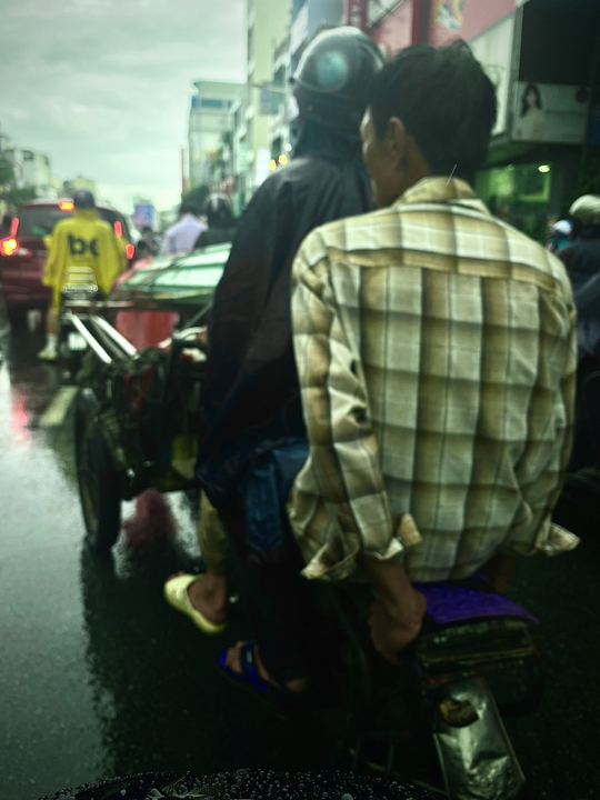 "Trước mặt tôi có 2 chú lái xe thồ chở tôn, người lái xe còn có áo mưa chứ chú ngồi sau trông không có vẻ gì bận tâm đến con mưa trên đầu mình cả"